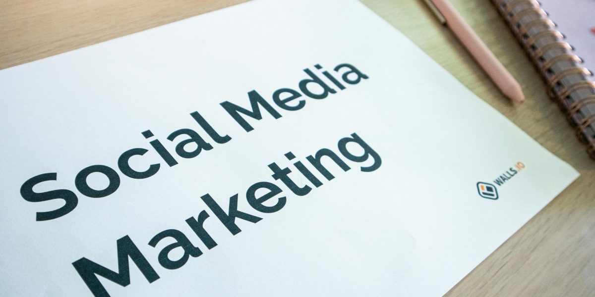 Close-up of a social media marketing document on a desk with a pen and notebook.